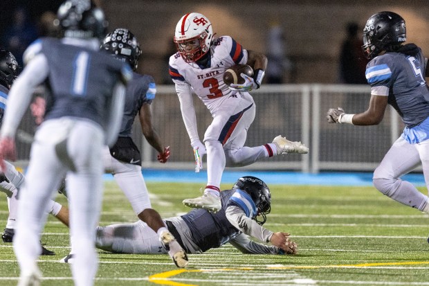 St. Rita's Langston Smith (3) hurdles a Willowbrook defender in the Class 7A second-round game in Villa Park on Friday, Nov. 8, 2024. (Vincent D. Johnson / for the Daily Southtown)