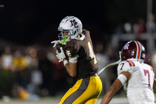 Mount Carmel's Quentin Burrell (4) hauls in a pass against Brother Rice during a CCL/ESCC Blue game in Chicago on Friday, Oct. 3, 2025. (Vincent D. Johnson / for the Daily Southtown)