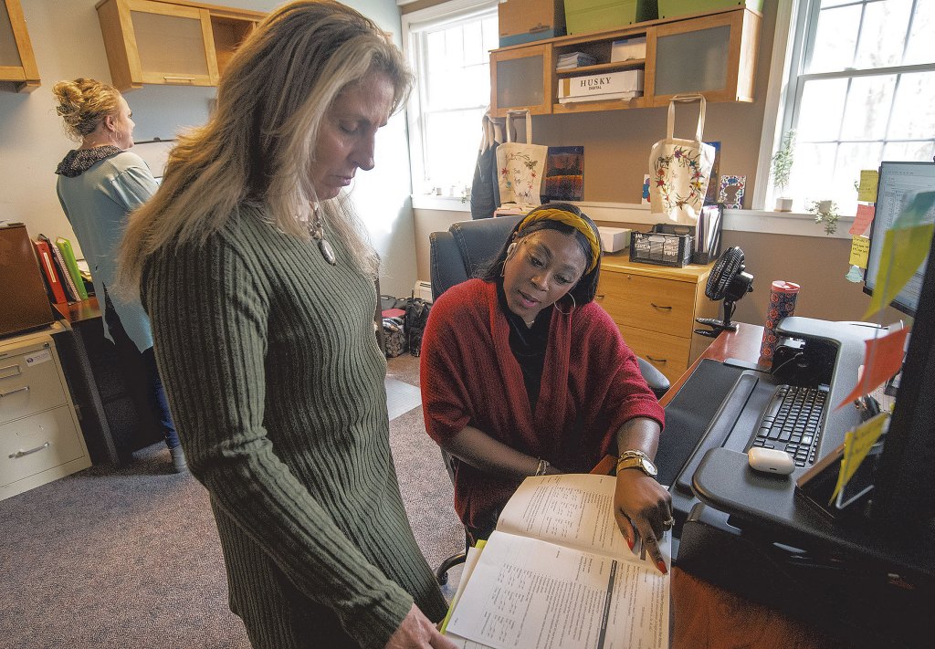 Caceirra Burton (right) and Shelly Weeks consult on a financial assistance application at the Family Center of Washington County