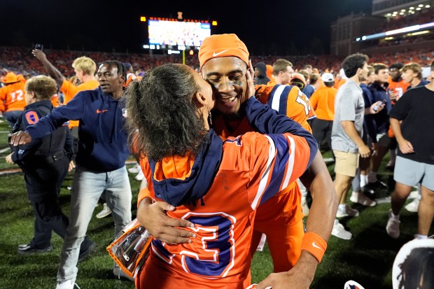 Illinois wide receiver Pat Bryant is kissed by his mom after the team's 23-17 upset win over Kansas after an NCAA college football game Saturday, Sept. 7, 2024, in Champaign, Ill. (AP Photo/Charles Rex Arbogast)