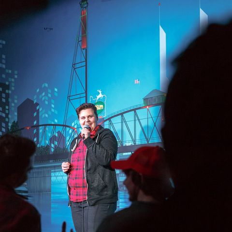 a comedian performs on stage at a comedy club
