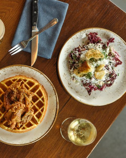 a spread of appetizing dishes alongside glasses and flatware on a wooden table