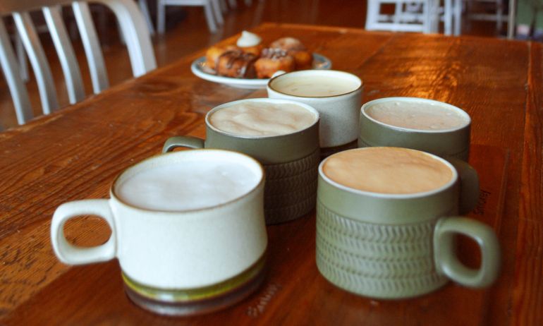 cups of chai on a cafe table with donuts