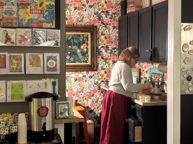 Lisa Komorowski, owner of Loulou Belle, prepares snacks and cider for shoppers in downtown Homewood, Dec. 18, 2025. (Evy Lewis/Daily Southtown)