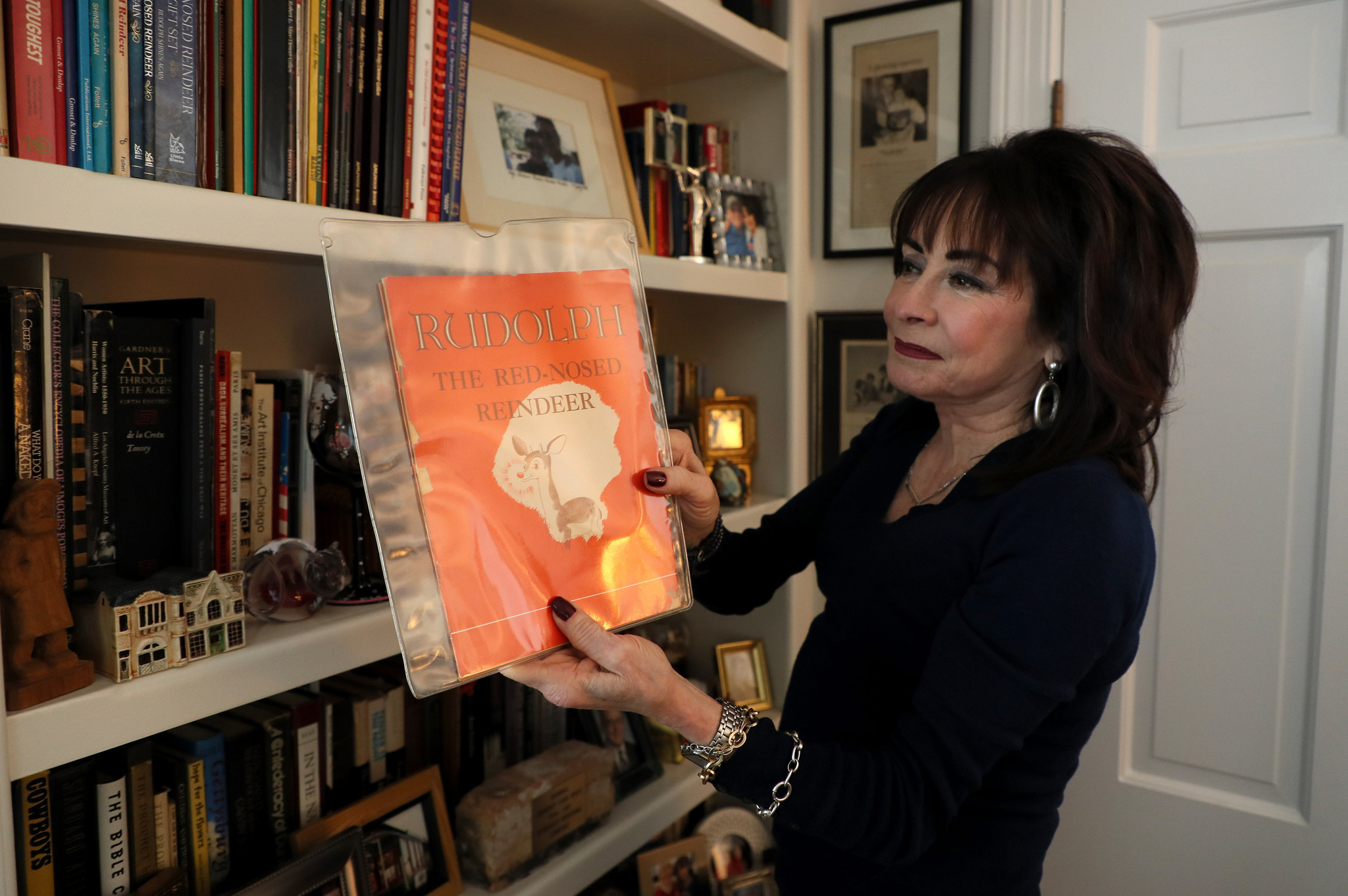 Martha May, daughter of Robert L. May, holds a copy of her father's original book of 