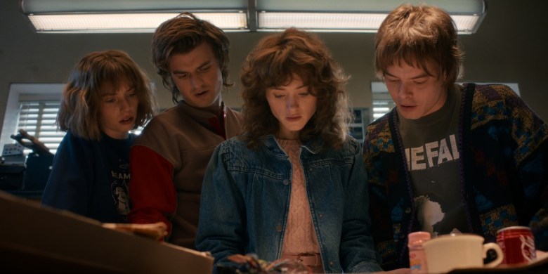 Maya Hawke as Robin Buckley, Joe Keery as Steve Harrington, Natalia Dyer as Nancy Wheeler, and Charlie Heaton as Jonathan Byers in Stranger Things: Season 5.