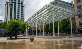 a large fountain and splash pad in a spacious urban park