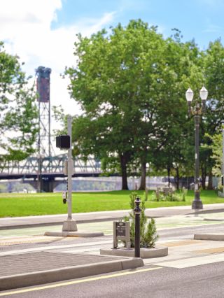 small sign on a street with a bridge in the background