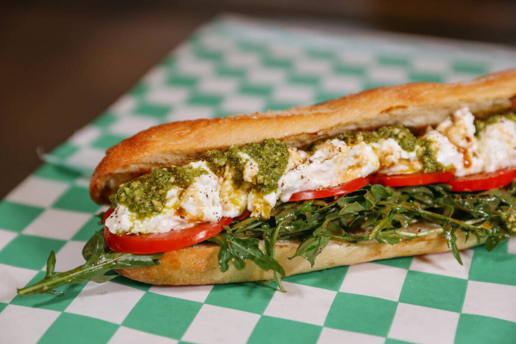 The Caprese sandwich, with stracciatella cheese, basil pesto, tomato, arugula and pomegranate m ...