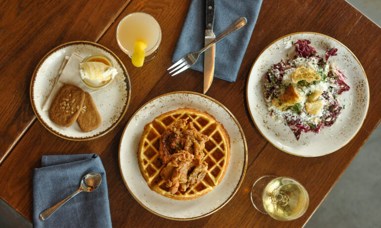 a spread of appetizing dishes alongside glasses and flatware on a wooden table