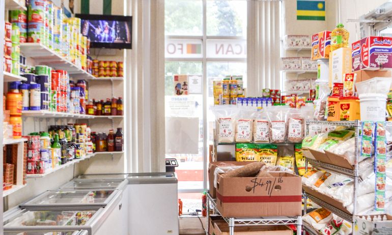 a sunlit and orderly store is filled with food items