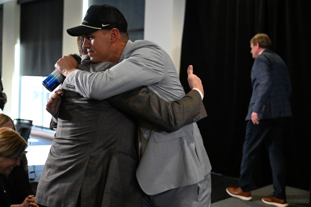 New University of Colorado Boulder athletics director Fernando Lovo, right, hugs outgoing athletics director Rick George, left, during an introductory press conference in the Nerdwallet Touchdown Club at the Dal Ward Athletic Center on Monday, Jan. 5, 2026. (Matthew Jonas/Daily Camera)