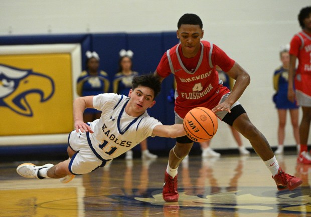 Sandburg's Jake Tomczak (11) lays out and tries to steal the ball away from Homewood-Flossmoor's Darrius Hawkins Jr (4) during a SouthWest Conference game Tuesday, Jan. 6, 2026 in Orland Park, IL. (Steve Johnston/for the Daily Southtown)