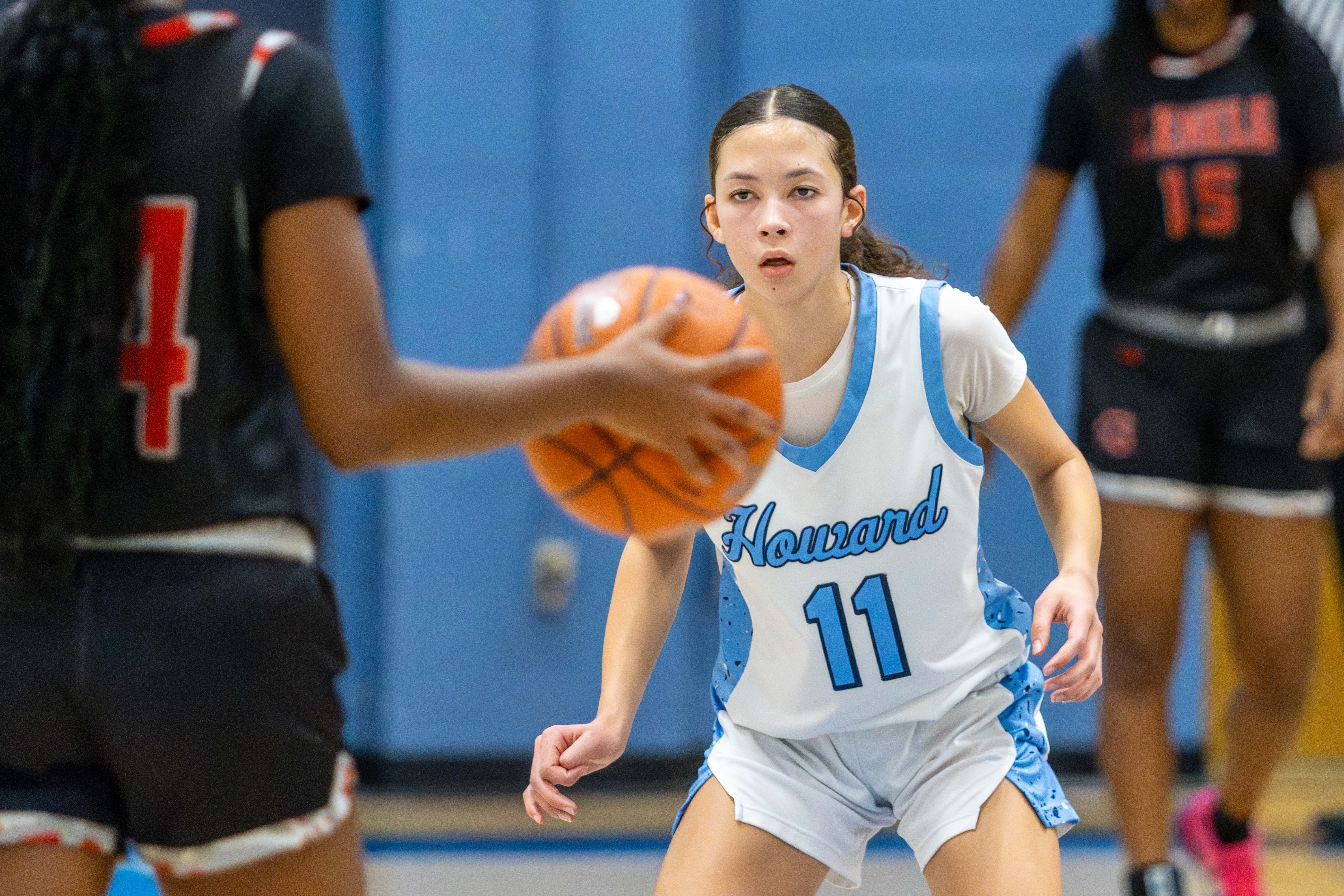 Sophomore Paige Watson, Howard, closely defends opponent while carrying ball...
