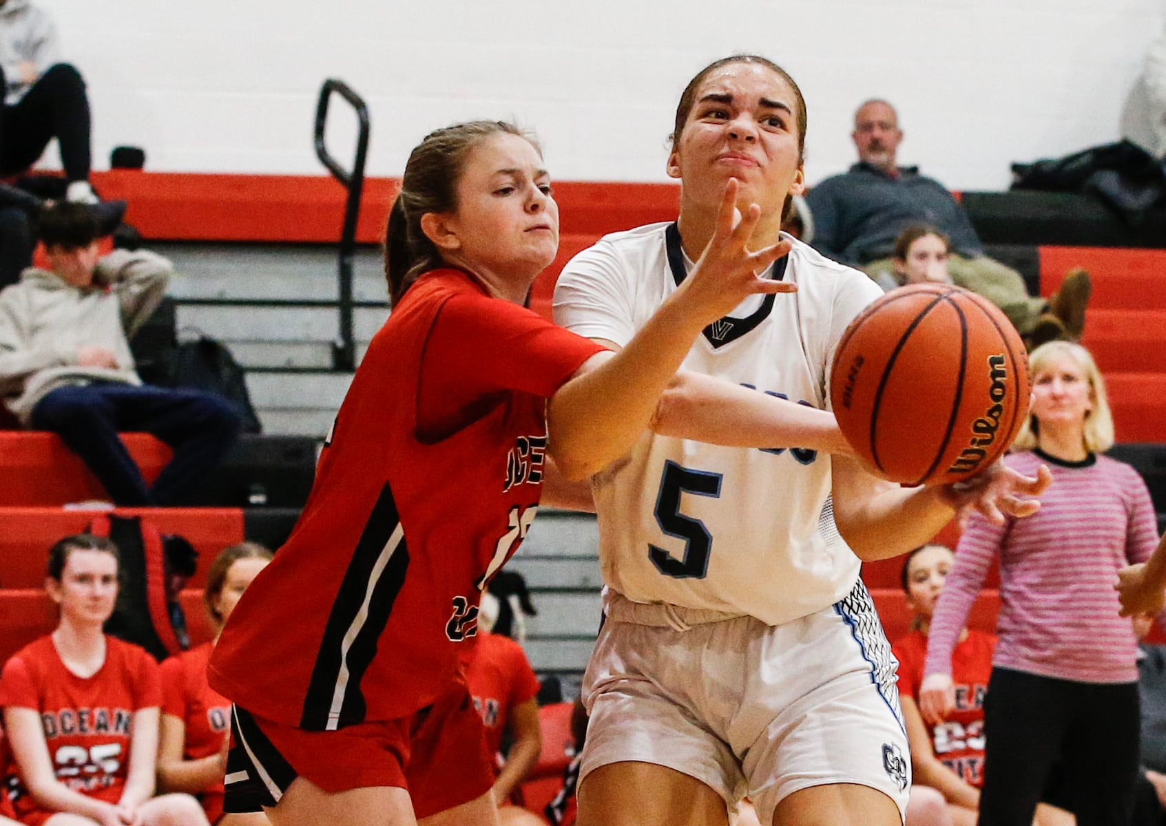 Casey Adamson (12) of Ocean City tries to block the pass for Laila Muniir (5) of Atlantic City during the girls basketball game between Ocean City and Atlantic City at Ocean City High School in Ocean City, NJ on 1/14/26.