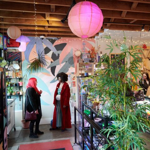 two people talking in the lobby of a cannabis shop with another person behind the counter