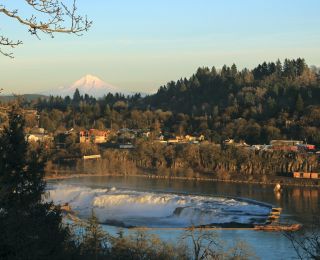 Sunset’s orange glow bath Mt. Hood’s snow capped peaks, Oregon City’s homes and Willamette Falls’ frothy waters.