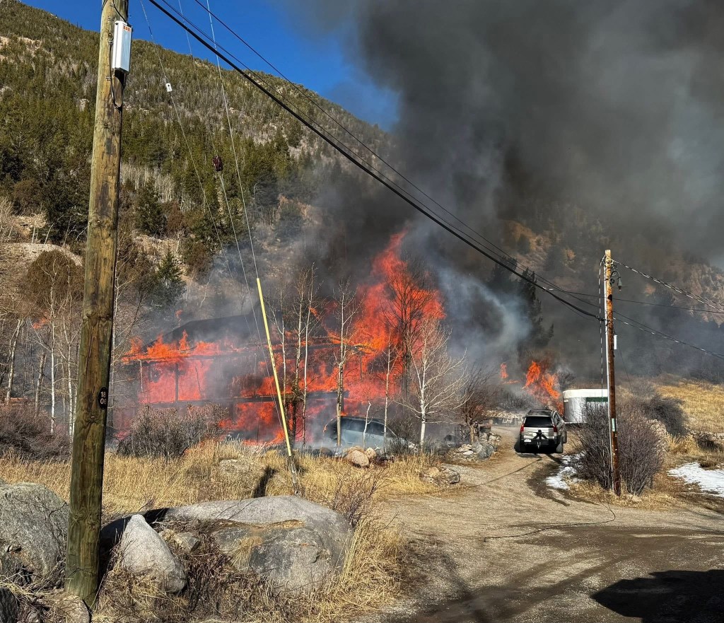 Brush fire sparks along I-70 in Colorado from house engulfed in flames
