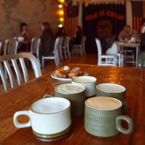 cups of chai on a cafe table with donuts