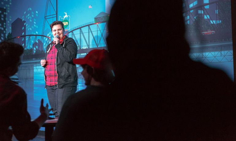 a comedian performs on stage at a comedy club