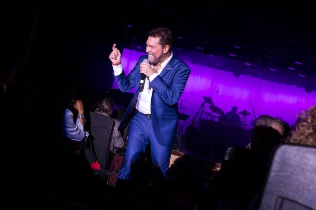 Clint Holmes steps off the stage and up the center aisle during opening night of his return to ...