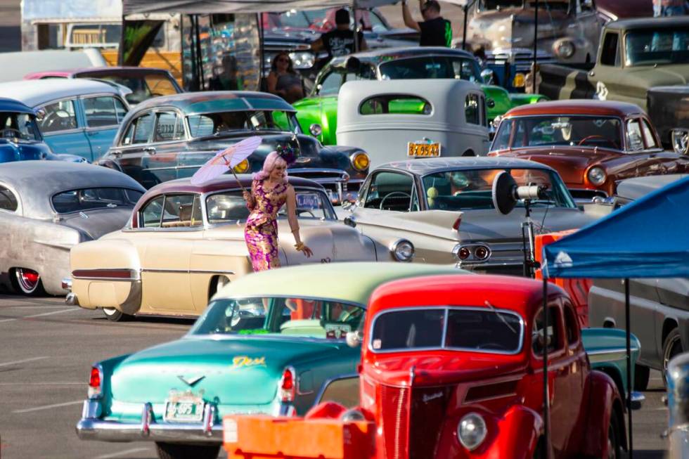 A model poses as vintage vehicles are set up ahead of the car show during the first day of Viva ...