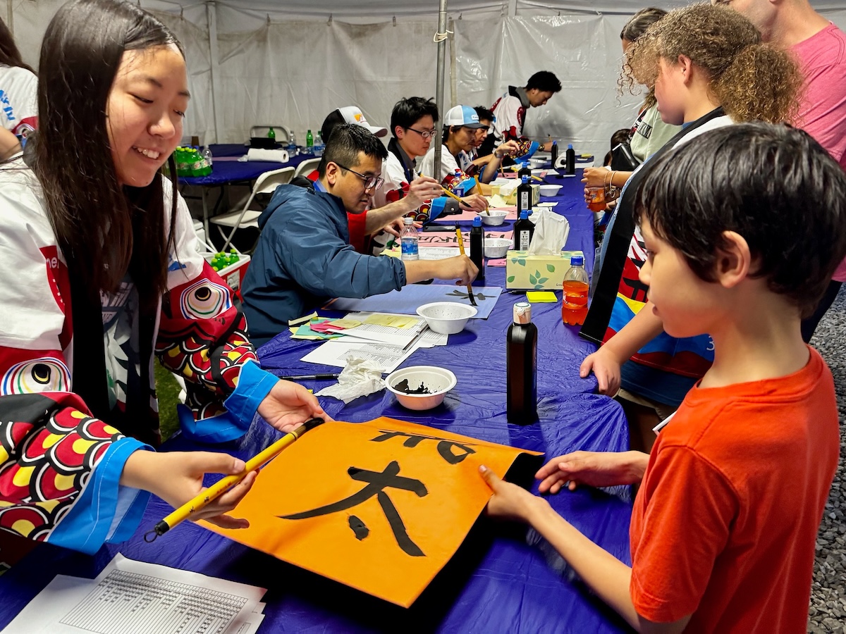 FREE Japanese festival in Decatur Friday, May 1 + how to go 3 A woman shows a child the art of Shodo–Japanese calligraphy at the Daikin Festival in Decatur, Alabama