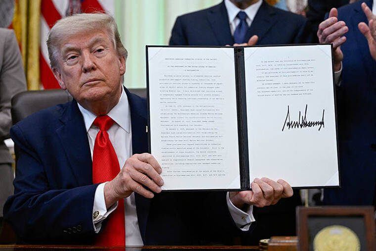 REUTERS/DANIEL HEUER
                                President Donald Trump holds a proclamation for restoring American commercial fishing in the Pacific, after signing it today in the Oval Office at the White House in Washington, D.C.