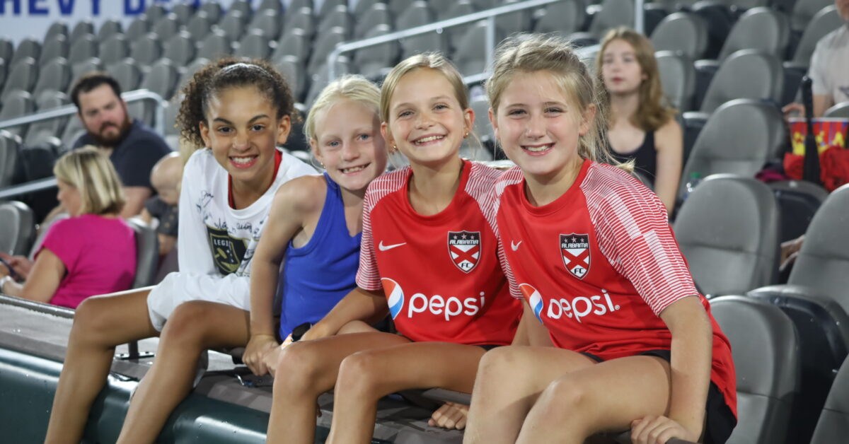 24 weekend events including Juneteenth + Father's Day celebrations (June 19-21) 3 Four young fans smiling in the stands at Protective Stadium, two wearing Alabama FC jerseys