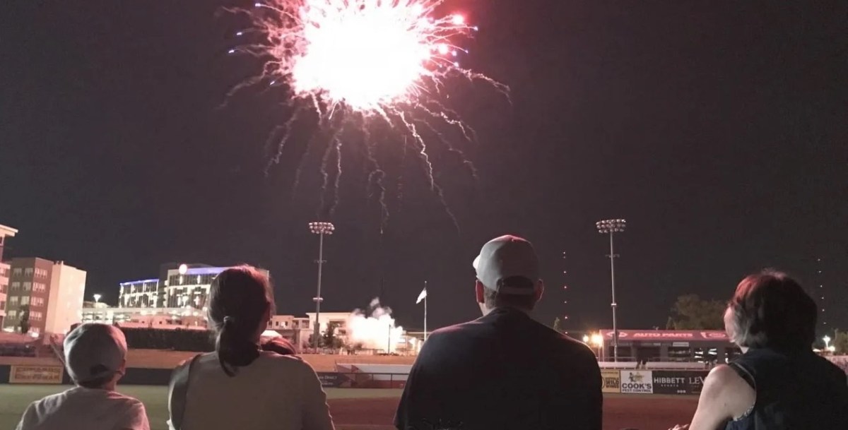 Crowd watching a fireworks show light up the night sky over Regions Field in Birmingham