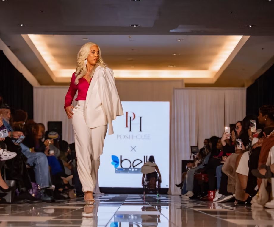 woman model in white suit walks down runway