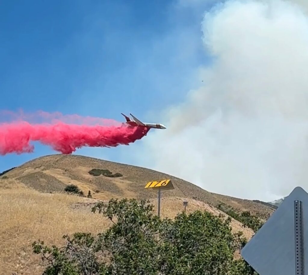 Watch aircraft drop fire retardand on the SLC foothills fire behind the U.
