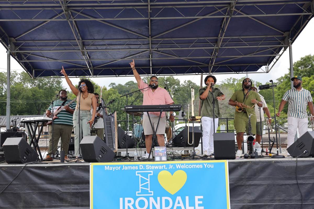 Live band performing on an outdoor stage at I Love Irondale Day, with an I Love Irondale sign displayed at the front of the stage