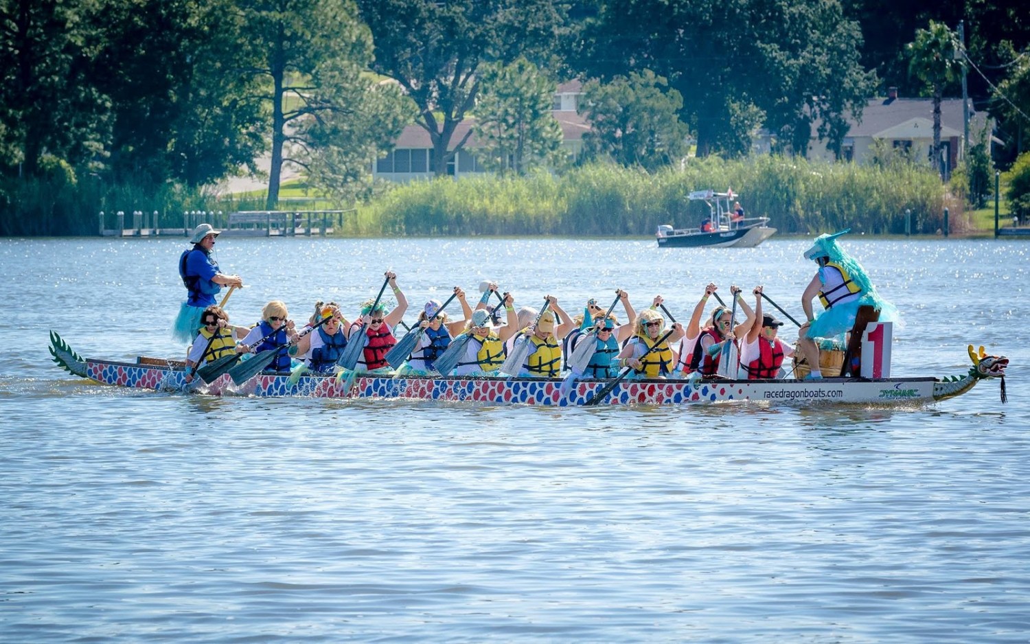 A team of paddlers in life jackets races a decorated dragon boat across East Lake during Mitchell's Place Dragon Boat Race Festival in Birmingham