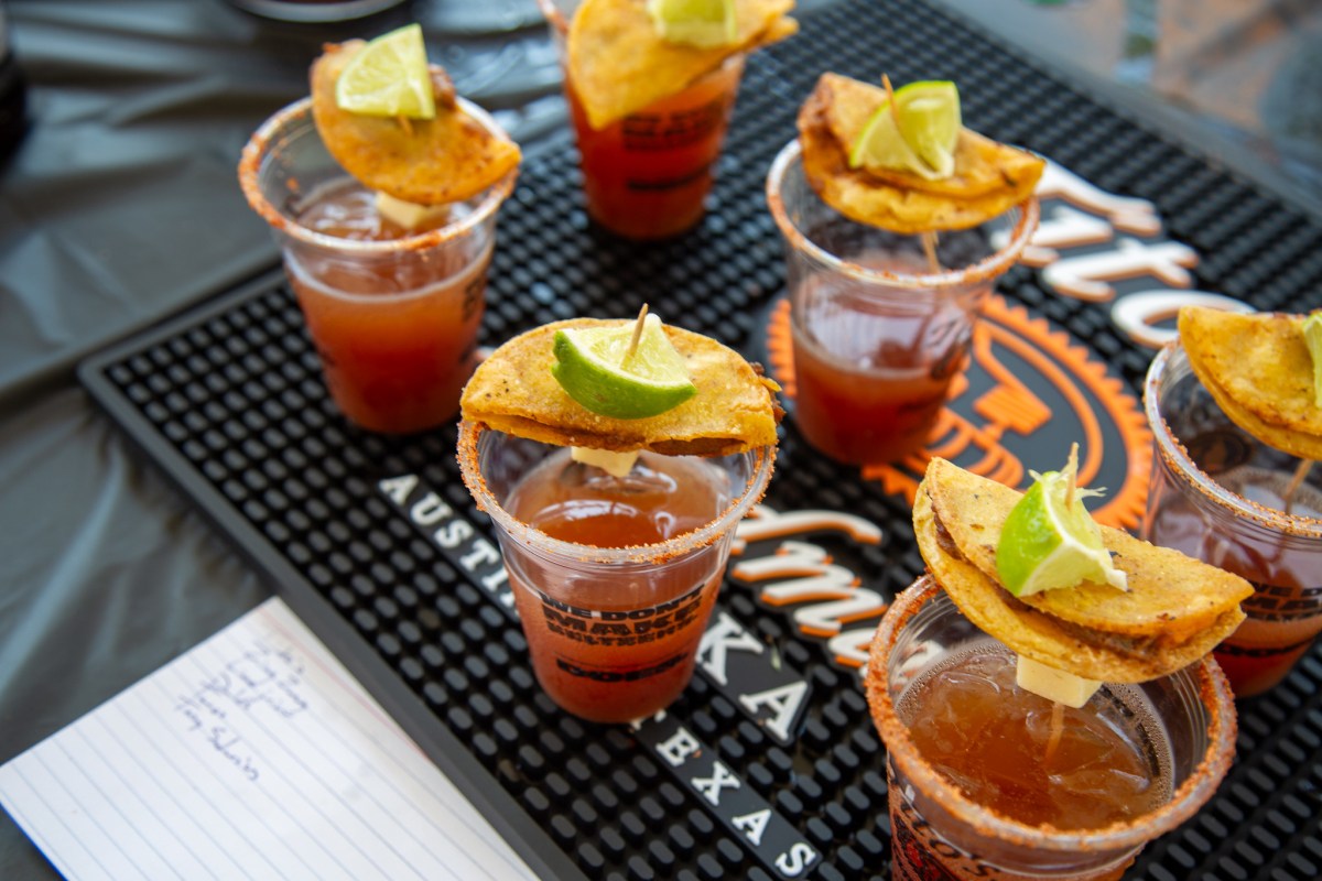 Cocktail contest entries garnished with lime wedges and tortilla chips displayed on a bar mat at the Dragon Boat Festival