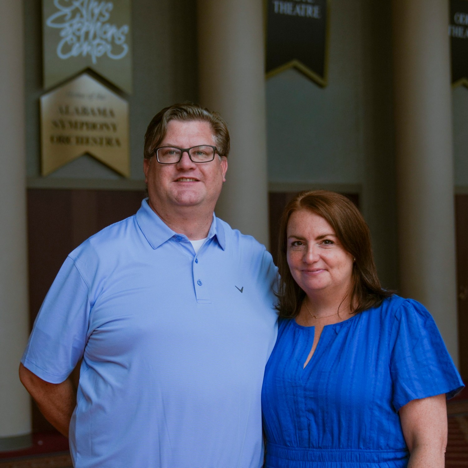 Man in light blue shirt wearing glasses poses next to woman in dark blue shirt at The Alys Stephens Center in Birmingham for United Ability
