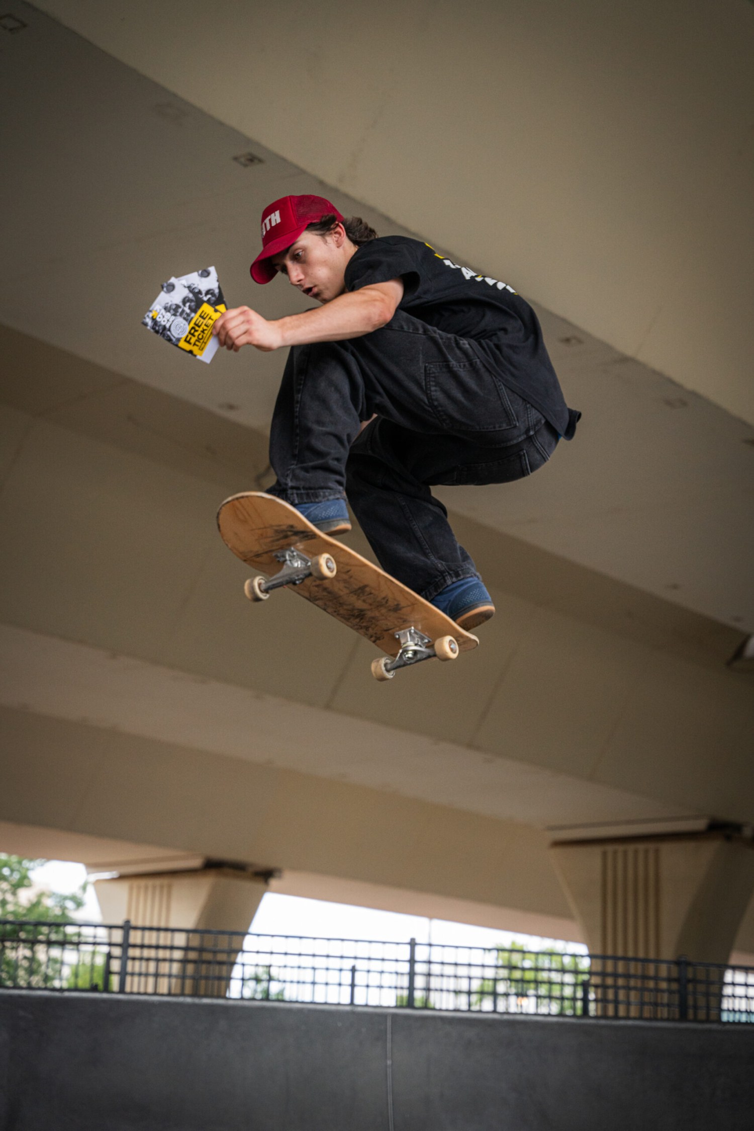The world's biggest action sports festival is coming to Birmingham—how to win VIP tickets 3 Skateboarder in a red cap and black jacket mid-air at a skate park, holding flyers while performing a trick