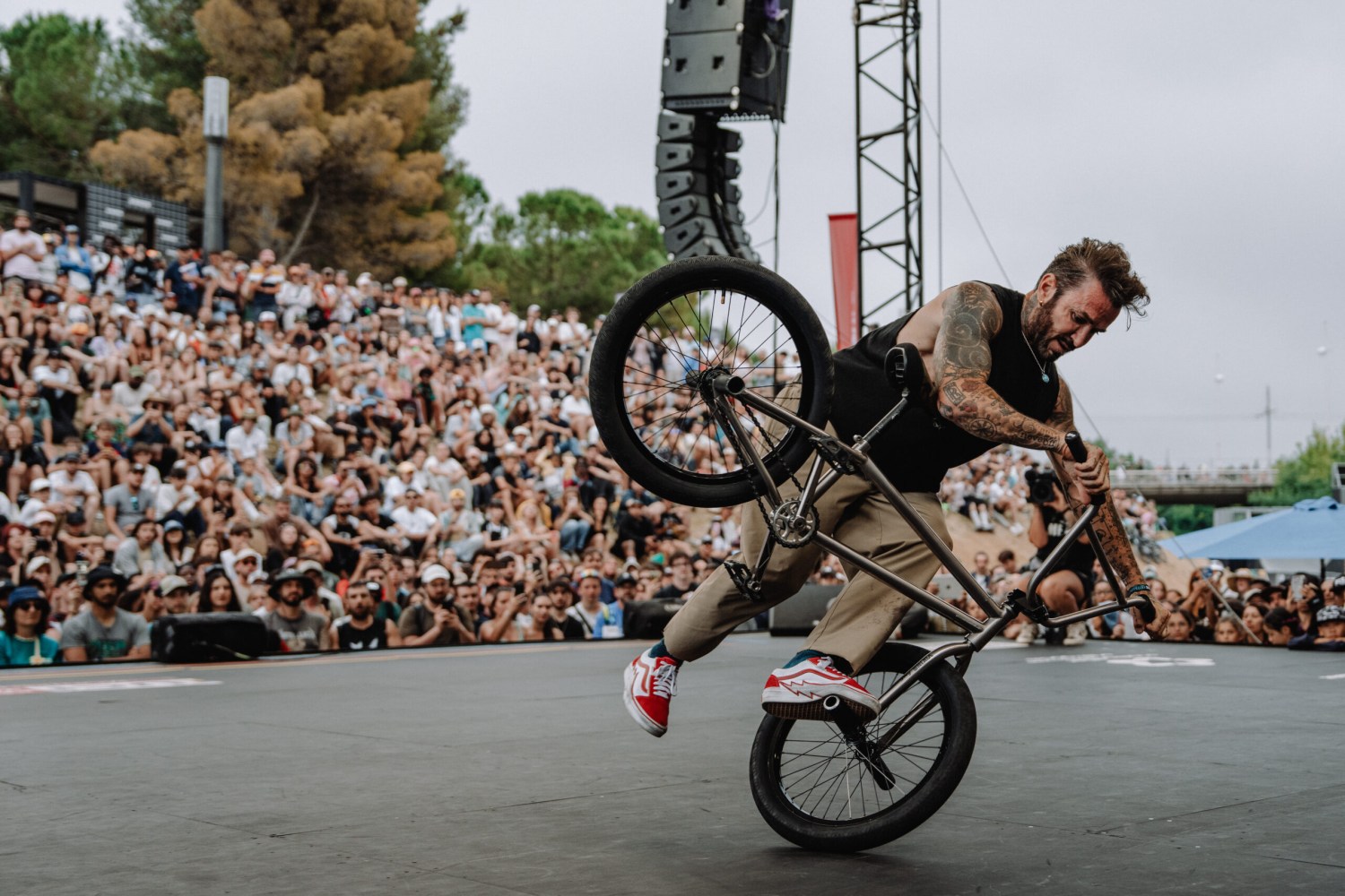 The world's biggest action sports festival is coming to Birmingham—how to win VIP tickets 4 Tattooed BMX rider performing a wheelie trick on stage before a large crowd at an outdoor event