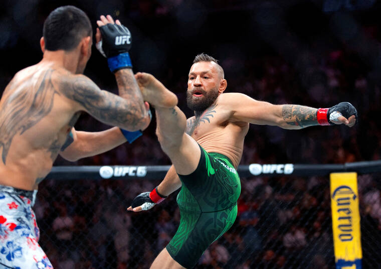 MARK J. REBILAS / IMAGN IMAGES
                                Conor McGregor (right) attempts a flying kick at the start of his fight against Max Holloway during UFC 329 at T-Mobile Arena.