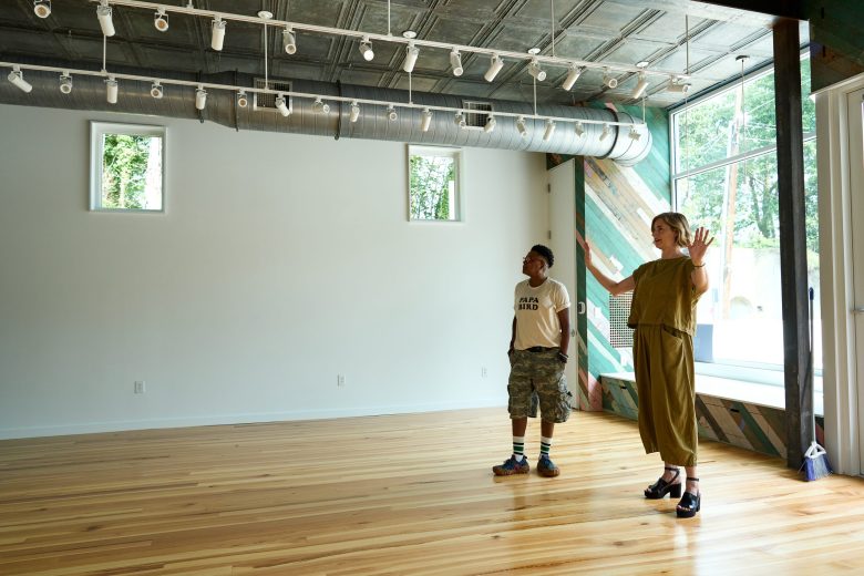(From left) Shirlette Ammons and Laura Ritchie show where an art gallery will be in Boardinghouse Arts. Photo by Matt Ramey.