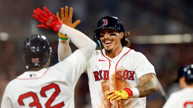 Boston Red Sox left fielder Jarren Duran (right) high-fives shortstop Andruw Monasterio (32) after Duran scores against the Chicago White Sox during the seventh inning at Fenway Park on Aug. 5, 2026, in Boston.