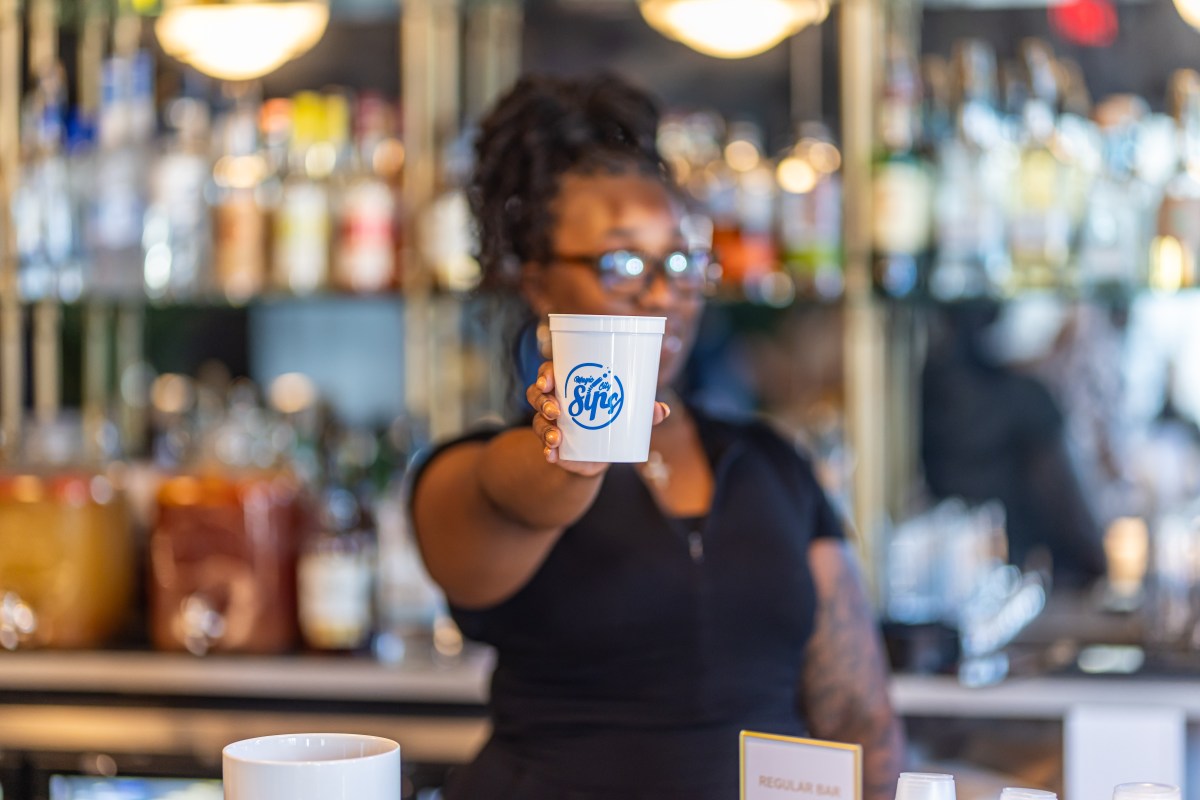 bartender holding cup out in front of themselves