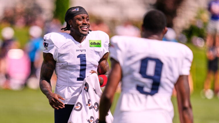 New England Patriots wide receiver A.J. Brown (1) talks with teammates while stretching during the team's NFL football training camp, Friday, July 31, 2026, in Foxborough, Mass.