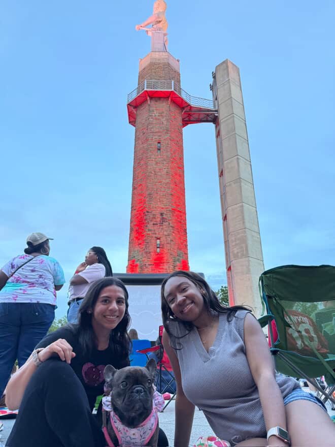 friends sitting in front of the vulcan statue
