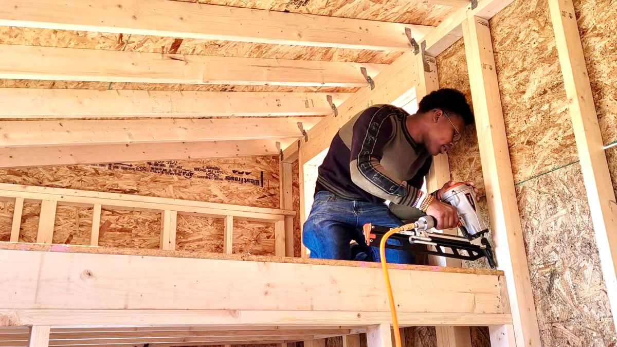student using nail gun in construction