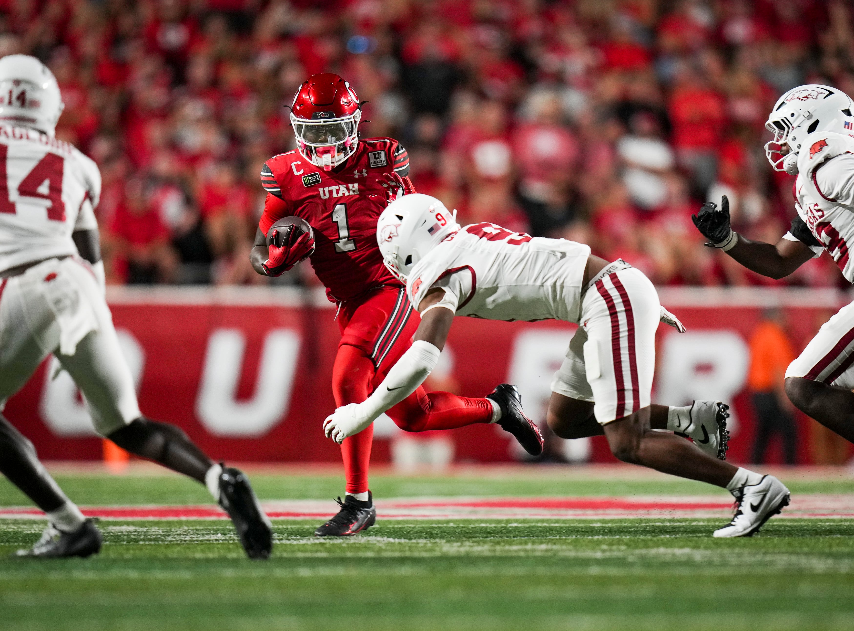(Bethany Baker  |  The Salt Lake Tribune) Utah Utes running back Wayshawn Parker (1) runs as he avoids a tackle from Arkansas Razorbacks defensive lineman Charlie Collins (9) during the game between the Utah Utes and the Arkansas Razorbacks in Salt Lake City on Saturday, Sept. 12, 2026.
