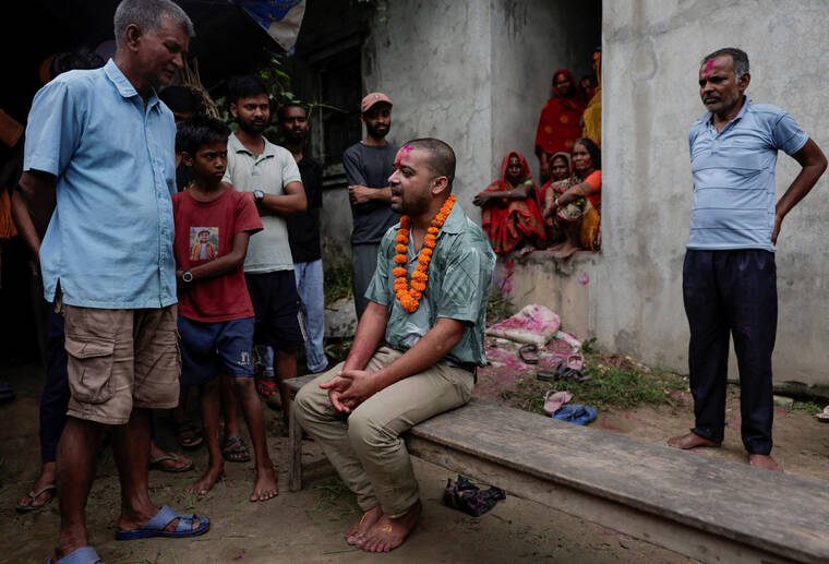 REUTERS/NAVESH CHITRAKAR
                                Sanjay Sah, a survivor pulled out alive after spending nine days trapped in a hydropower station tunnel following flash floods and a mudslide, speaks with the well-wishers and family members upon his arrival home for the first time after being rescued from the tunnel, as his father Ram Phal Sah stands behind him, in Tilathi Koiladi village in Saptari District, Nepal.