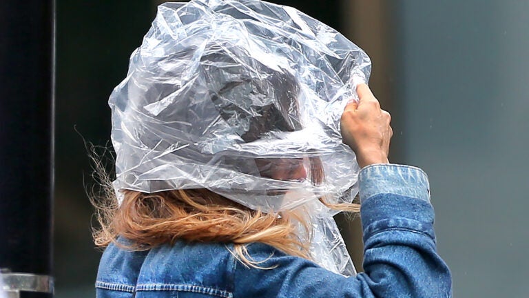 People deal with the effects of strong winds and rain.