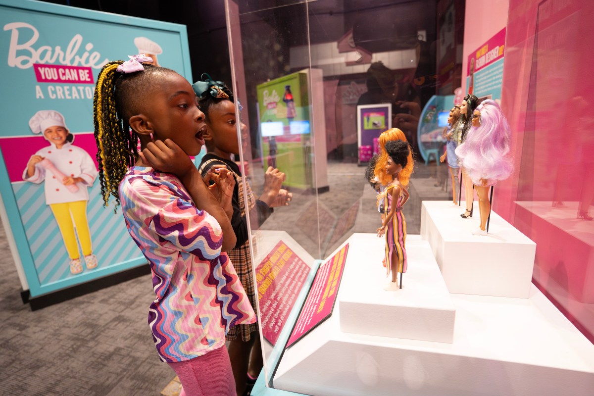 Kids marvel at Barbie dolls on display in the "You Can Be a Creator" exhibit