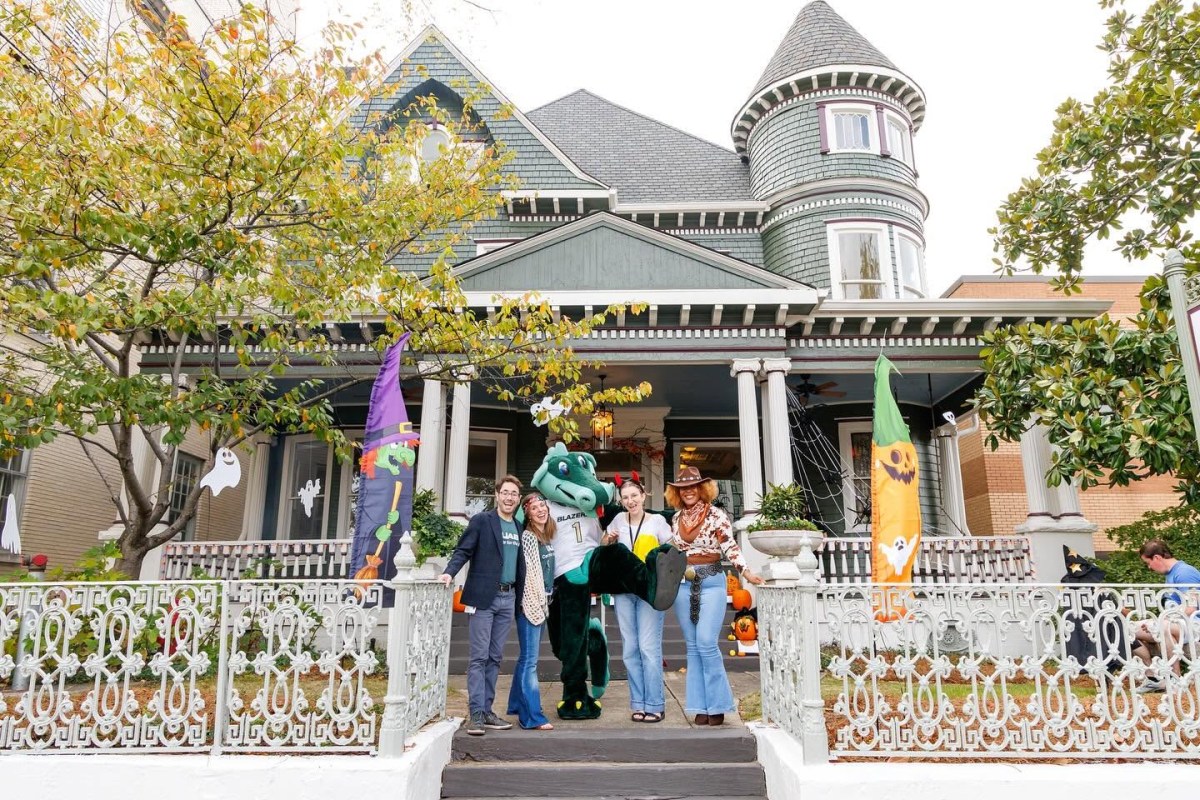 32 family-friendly Halloween events in Birmingham 6 UAB's Blaze mascot poses with people on the porch of a Victorian house decorated with Halloween flags for a fall event